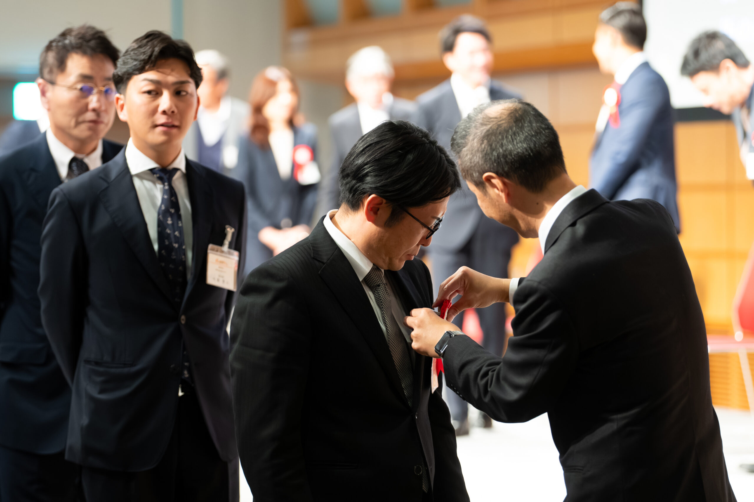 加盟店表彰店舗にロゼットをつける様子