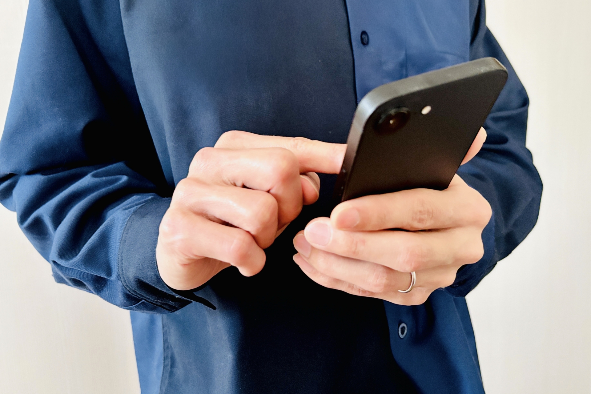 スマホを操作する男性の手元
